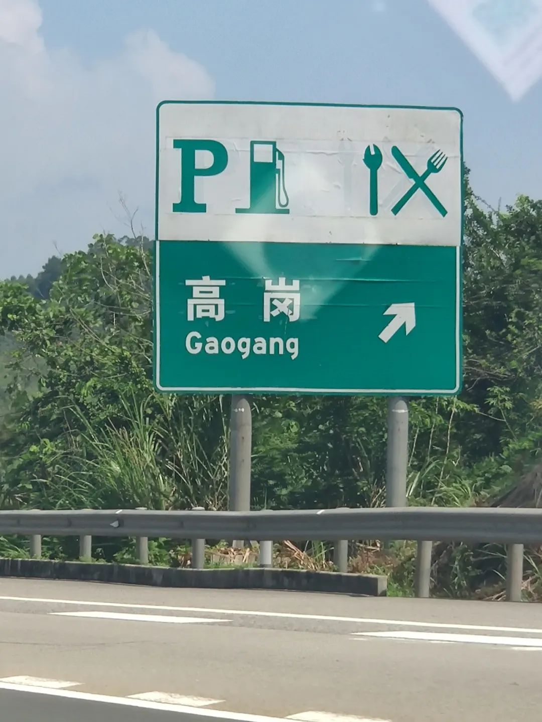 A highway sign has reserved a position for a charging station.