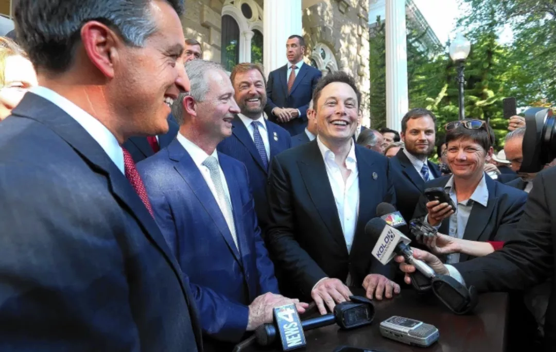 On the day of the signing, Brian Sandoval (far left), executive director of the Nevada Office of Economic Development Steve Hill (second from left) and Musk (third from left) accept media interviews.