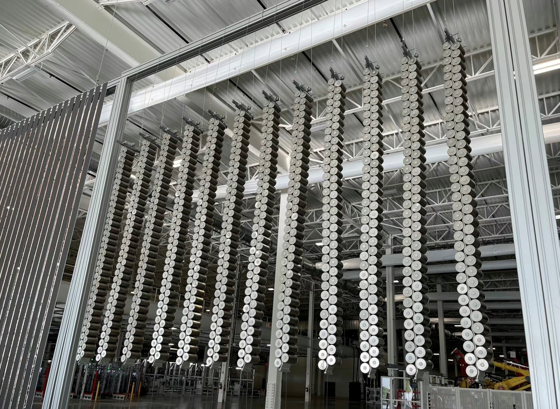 4680 battery cells hanging in the air, 1 column of 34 or 35 cells.
